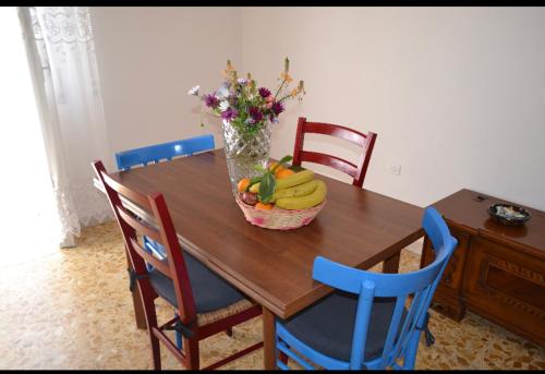 a wooden table with a basket of fruit on it at Flat in Olbia Centro in Olbia
