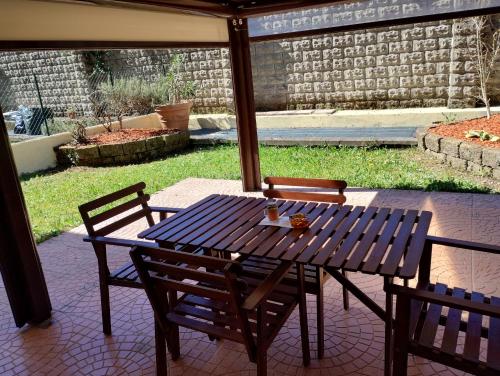 a wooden table and chairs on a patio at Border House in Gorizia