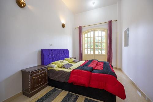 een slaapkamer met een blauw bed en een raam bij Noby Guest House in Luxor