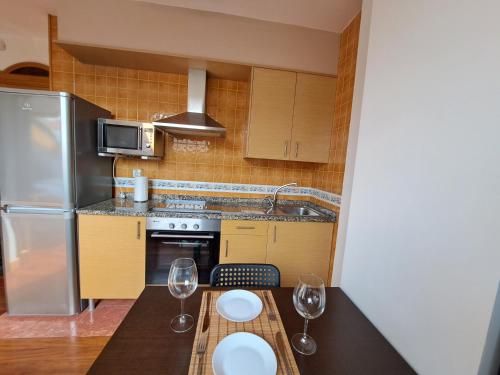 a kitchen with a table and two wine glasses at Vigo centro, ático. in Vigo