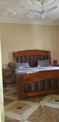1 dormitorio con 1 cama grande de madera en una habitación en The bb's, en Brusubi