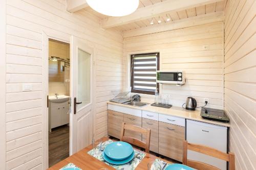 eine Küche mit Holzwänden und einem Tisch mit einer blauen Schüssel in der Unterkunft MarkoweDomki,pl in Jantar