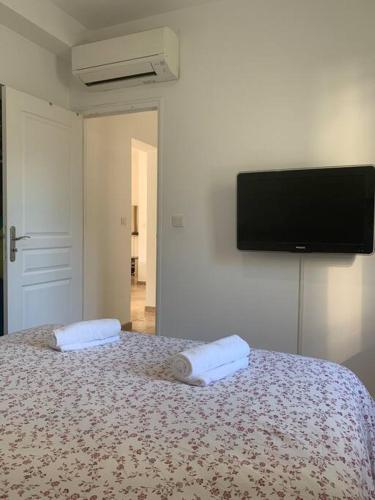 - une chambre avec un lit et une télévision murale dans l'établissement Appartement à 200m des plages., à Fréjus