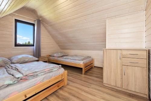 Cette chambre comprend 2 lits et une fenêtre. dans l'établissement MarkoweDomki,pl, à Jantar