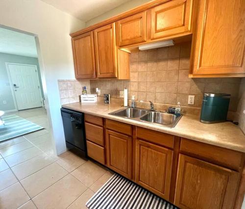 a kitchen with wooden cabinets and a sink at Beach Bungalow in downtown Cocoa Beach in Cocoa Beach