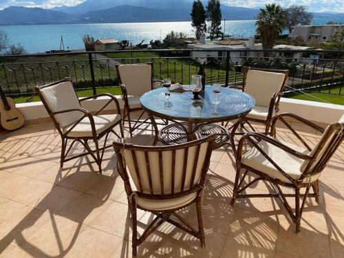 szklany stół i krzesła na patio w obiekcie Country house Nafpaktos w mieście Nafpaktos