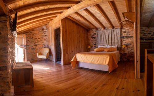 sypialnia z łóżkiem w pokoju z drewnianą podłogą w obiekcie Xisto Sentido w mieście Martim Branco