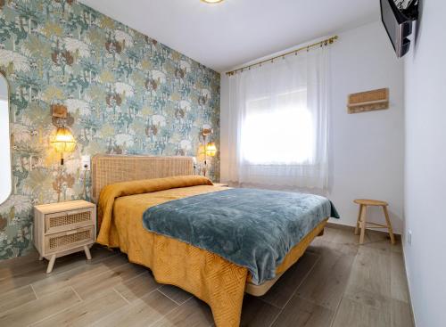 1 dormitorio con 1 cama grande y papel pintado con motivos florales en Chalet Marinera Riumar Pura Natura en Riumar