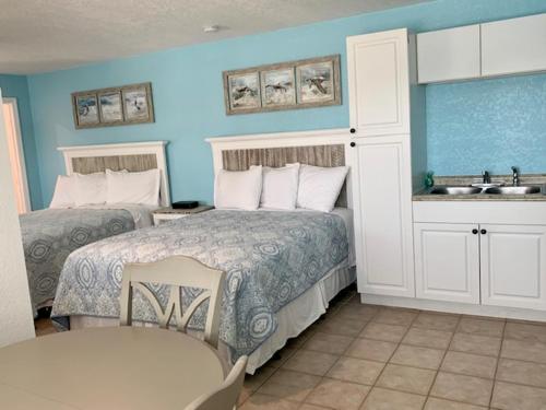 a bedroom with two beds and a sink in it at Tropical Cottages in Marathon