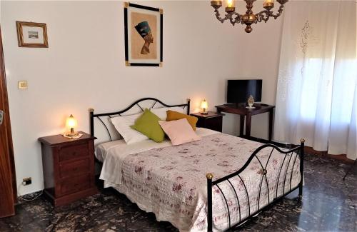 1 dormitorio con 1 cama con 2 mesas y una lámpara de araña en OPERA21 TUSCANY SINGLE HOUSE LUCIGNANO, en Lucignano