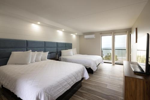 a hotel room with two beds and a balcony at Aventura on the Ocean in Myrtle Beach