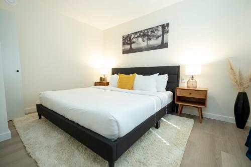 a bedroom with a large white bed and a table at The Francis Boutique Inn in Ucluelet