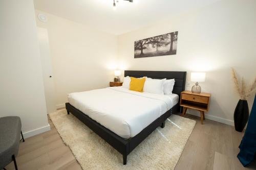 a bedroom with a large bed with white sheets and yellow pillows at The Francis Boutique Inn in Ucluelet