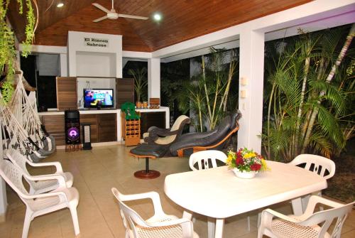 d'une terrasse avec une table, des chaises et une télévision. dans l'établissement Incluye auxiliar doméstica PISCINA PRIVADA, à Girardot