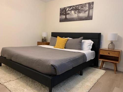 a bedroom with a black bed with yellow pillows at The Francis Boutique Inn in Ucluelet