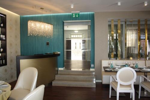 a restaurant with white chairs and a blue wall at Josefa D`Obidos Hotel in Óbidos