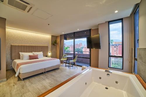 a hotel room with a bed and a bath tub at Eutopiq Hotel in Medellín