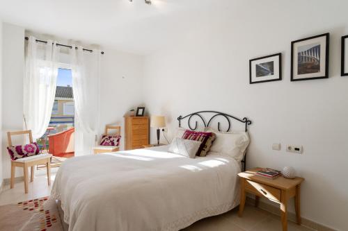 - une chambre avec un grand lit blanc et une fenêtre dans l'établissement CB Living - Apartment with roof terrace Aguamarina, à Orihuela Costa