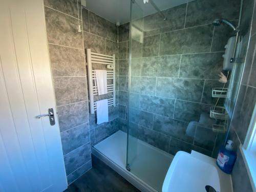 a bathroom with a glass shower with a toilet at East Coast Chalets 333 Sunny Corner at California Sands in Great Yarmouth