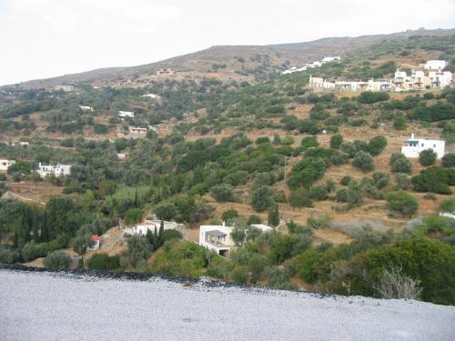 a house on a hill next to a body of water at The Antique House in Batsi