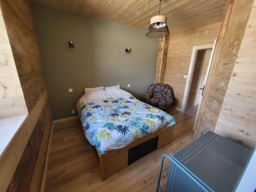 a small bedroom with a bed and a chair at La Fessette in Chapelle-des-Bois