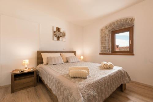 um quarto com uma cama grande e uma janela em Kuća za odmor Gino em Šajini