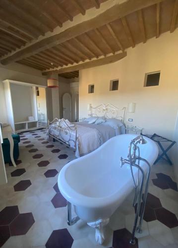 a bathroom with a tub and a bed and a bath tub at punti di vista in Bibbona