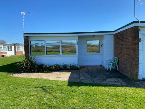 a house with a white door and a brick building at East Coast Chalets 300 Dog friendly at California Sands in Scratby
