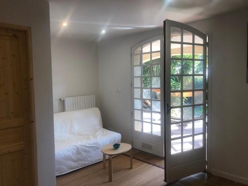 ein Zimmer mit einem Bett und einem Tisch und einem Fenster in der Unterkunft Une terrasse à L’Estaque + stationnement in Marseille