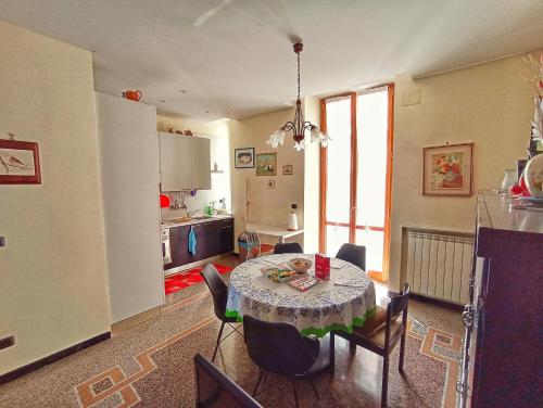 uma cozinha e sala de jantar com mesa e cadeiras em La casa sul mare-Savona em Savona