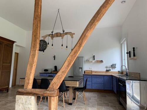 kuchnia z niebieskimi szafkami i stołem z krzesłami w obiekcie Gîte, Maison entière avec billard et bel espace de vie La Grange w mieście Blicourt