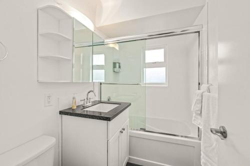 een witte badkamer met een wastafel en een douche bij Peaceful Escape in Victoria