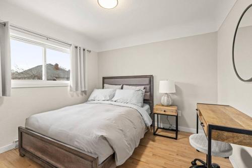 een slaapkamer met een bed, een bureau en een raam bij Peaceful Escape in Victoria