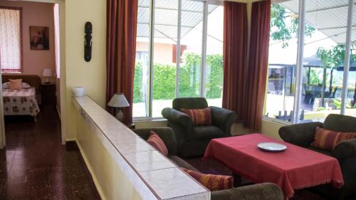 a living room with a couch and chairs and a table at House of Erabo in Runaway Bay