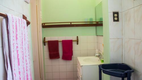 a bathroom with a sink and red towels at House of Erabo in Runaway Bay