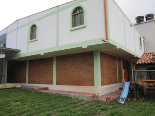 a large white building with a playground in front of it at Cabaña y apartamentos in Chinácota