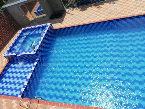 an overhead view of a swimming pool with blue water at Cabaña y apartamentos in Chinácota