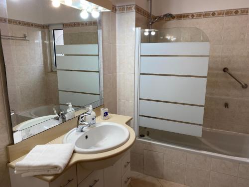y baño con lavabo, ducha y bañera. en Beautiful apartment in Ferragudo, en Ferragudo