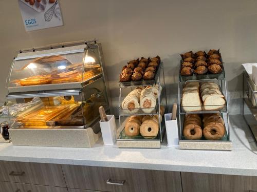 a display case with various types of donuts and pastries at Days Inn by Wyndham Yosemite Area in Fresno