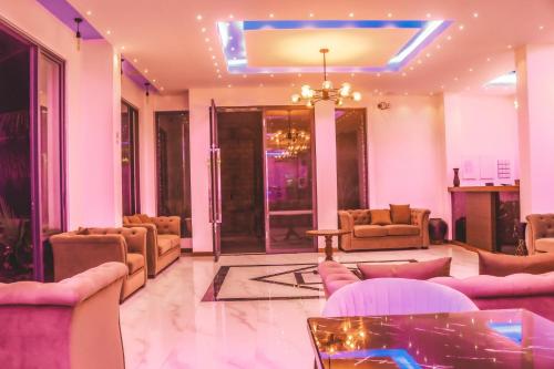 a lobby with couches and chairs and a chandelier at Ari Grand Hotel & Spa in Dhangethi