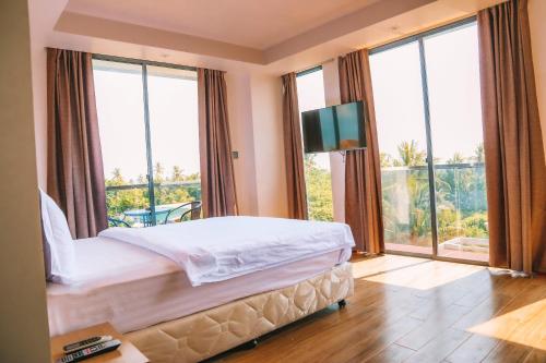 um quarto com uma cama e uma grande janela em Ari Grand Hotel & Spa em Dhangethi