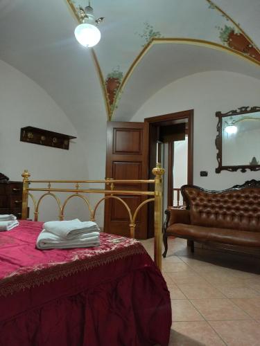 a bedroom with a bed and a couch and a television at Meraviglie Salentine in Lequile