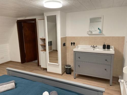 La salle de bains est pourvue d'un lavabo et d'un miroir. dans l'établissement Ferienhaus Zorgenfrei, à Walkenried