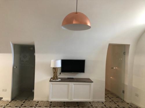 Zimmer mit einem TV und einem Tisch mit einer Lampe in der Unterkunft Dimora Estlevante in Vieste