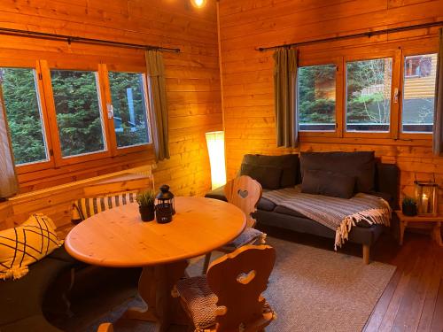 a living room with a table and a couch at Ferienhaus-Blockhütte im Fichtelgebirge - Nagler See 2 km in Nagel