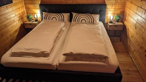 a large bed in a room with two tables at Ferienhaus-Blockhütte im Fichtelgebirge - Nagler See 2 km in Nagel