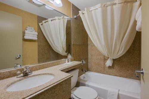 a bathroom with a sink and a toilet and a tub at Quality Inn JFK Airport Rockaway Blvd in Queens