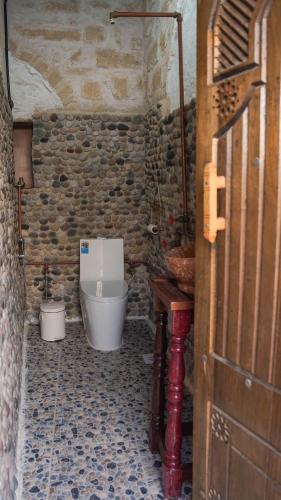 a small bathroom with a toilet and a sink at نزل كوفان التراثي Koofan Heritage Lodge in Salalah
