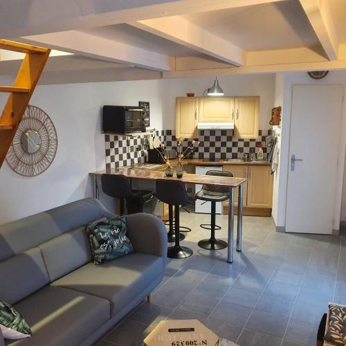 a living room with a couch and a kitchen at Petite maison mitoyenne avec terrasse in Saint-Julien-de-Concelles