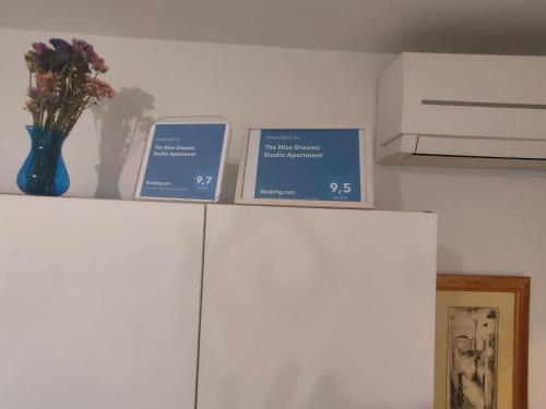 a shelf with three signs on top of a refrigerator at The Nice Dreams Studio Apartment in Zadar
